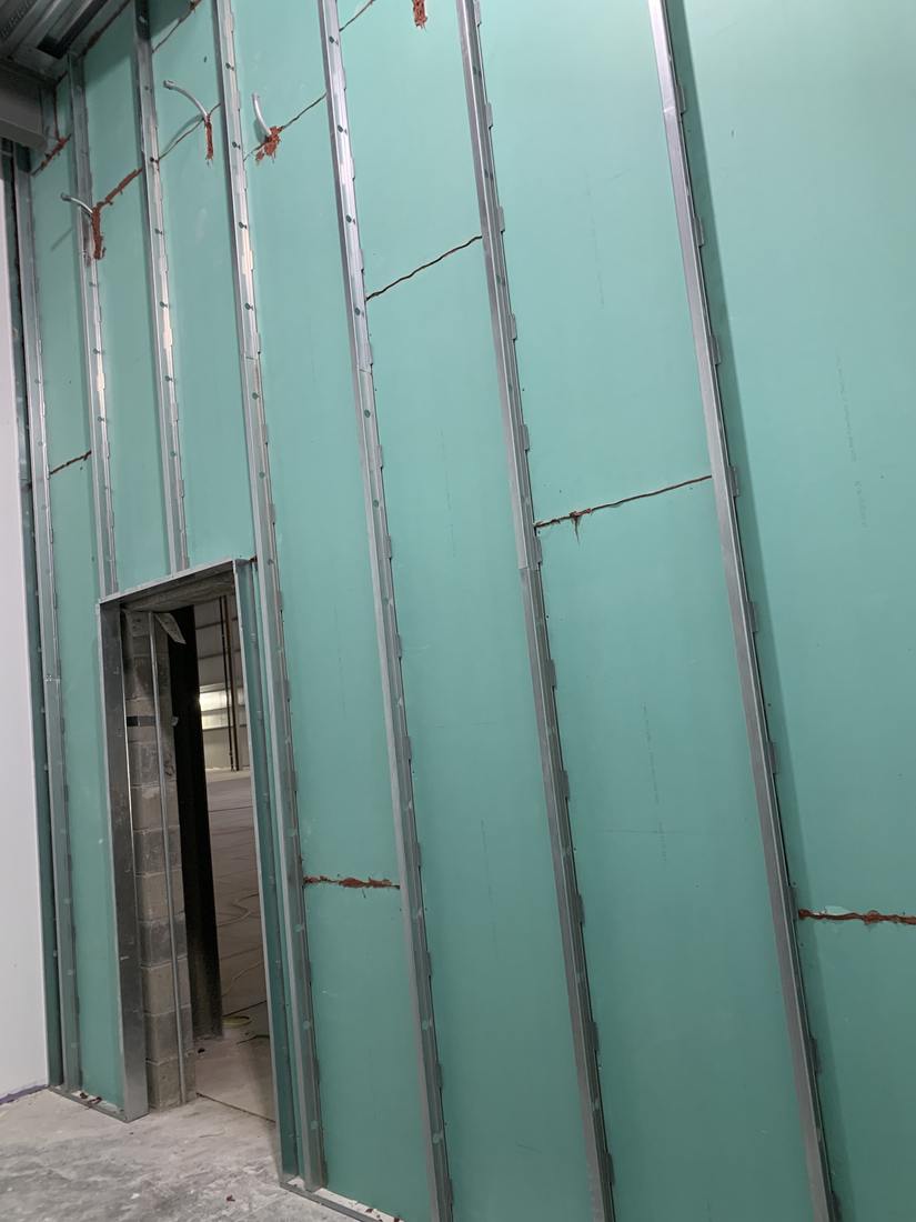 Moisture-resistant board hung along a block wall